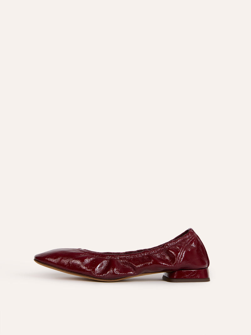 NINA burgundy patent leather ballet flats worn on a model by Rouje
